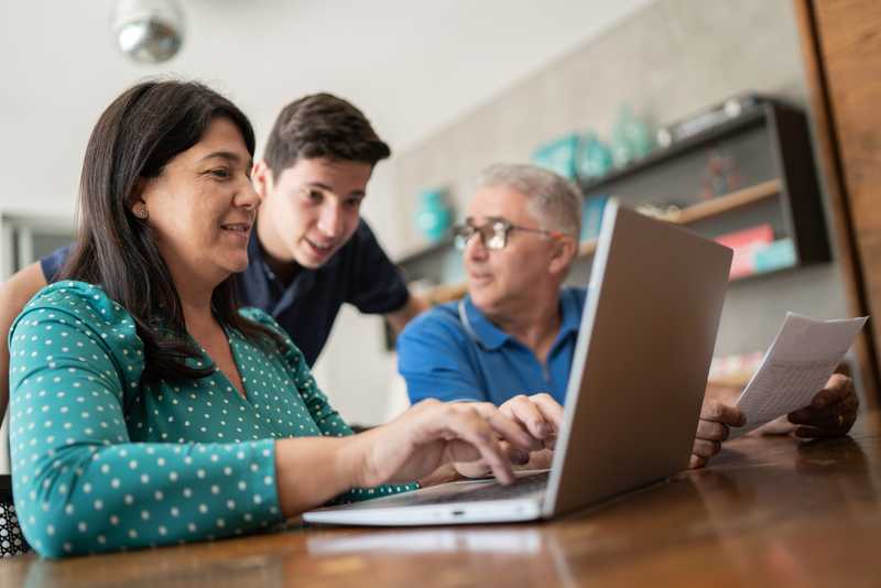 A family viewing a laptop together and talking