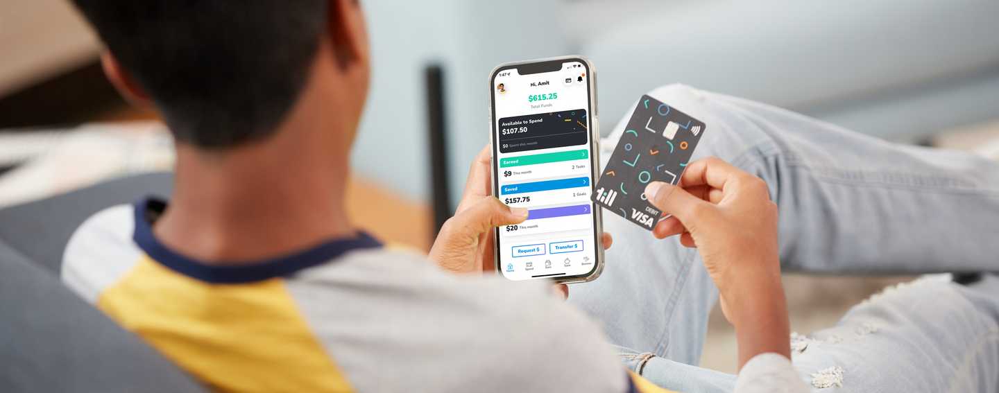 Teenager holding a Till debit card and a phone showing the home screen of the Till financial app