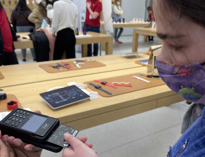 Teenager using a Till debit card to make a purchase in an Apple store