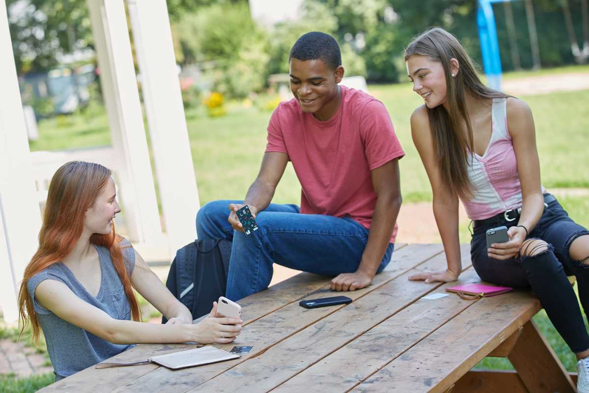 Teenagers discussing their Till cards and mobile application