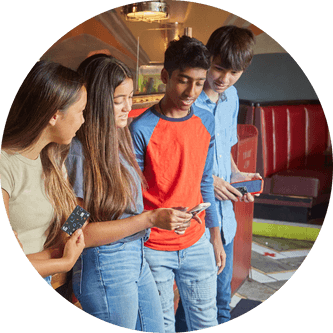 Group of four kids looking at the Till App on one of the kid's phones
